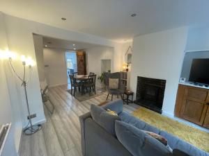 a living room with a blue couch and a fireplace at Tucked away house in Macclesfield in Macclesfield