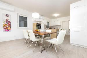 a kitchen and dining room with a wooden table and white chairs at Apartments Tony in Mali Lošinj +34 photos