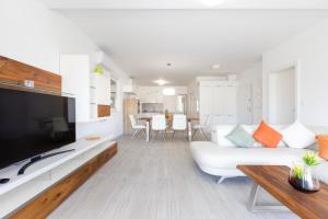 a living room with a white couch and a tv at Apartments Tony in Mali Lošinj