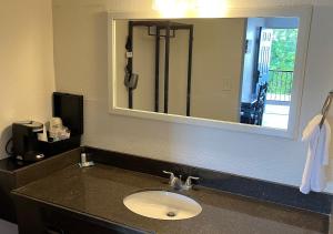 a bathroom with a sink and a large mirror at Ballparks Inn in Branson