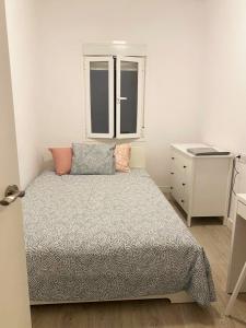 1 dormitorio con 1 cama, vestidor y ventana en Malvarrosa Private Rooms in Shared Apartment en Valencia