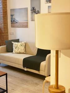a living room with a couch and a lamp at Malvarrosa Private Rooms in Shared Apartment in Valencia