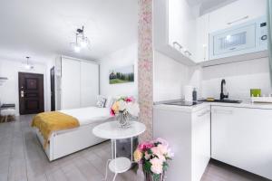 a white bedroom with a bed and a table with flowers at Studio Oscar in Saturn