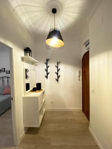 Habitación blanca con una luz colgada del techo en Malvarrosa Private Rooms in Shared Apartment, en Valencia