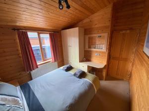 a bedroom with a bed in a wooden cabin at Surf Lodge in West Down