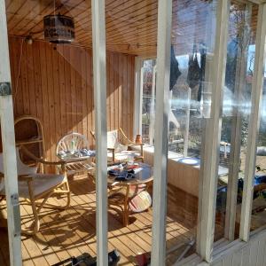 een afgeschermde veranda met een tafel en stoelen bij Villagehome North Jylland in Sindal