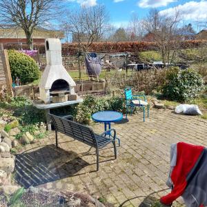 a patio with a bench and a table and a fireplace at Villagehome North Jylland in Sindal