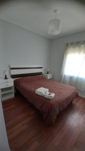 a bedroom with a bed with a red blanket and a window at Centro Norte lll con cochera incluida in Bahía Blanca