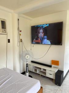 a bedroom with a flat screen tv on a wall at Maria Kulafu Studio Apartment Kinamaligan- Beside Eglin Gas FREE Wifi in Masbate