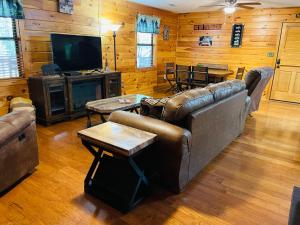 uma sala de estar com dois sofás e uma televisão em Smoky Mountain Enchanting Haven 3BR2BA Cabin em Sevierville