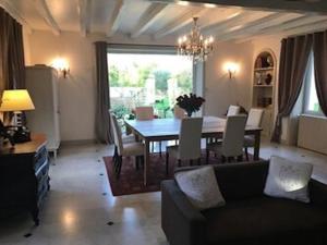 a living room with a dining table and a couch at Le Clos des Marais in Champagné-les-Marais