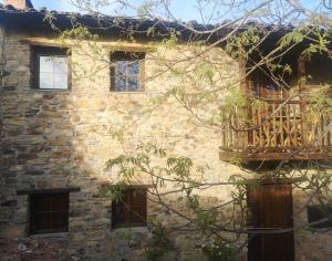 un antiguo edificio de piedra con balcón. en Casa do Parâmio - Montesinho, en Parâmio