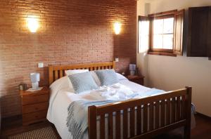 - une chambre avec un lit et un mur en briques dans l'établissement Casa do Parâmio - Montesinho, à Parâmio