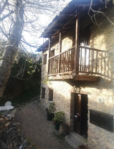 un edificio con un balcón de madera en un lateral en Casa do Parâmio - Montesinho, en Parâmio