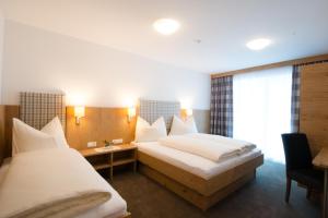 イシュグルにあるApart Stella Alpinaのベッド2台と窓が備わるホテルルームです。