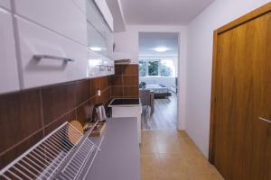 cocina con paredes blancas y puerta de madera en RIVERVIEW, en Niš