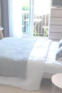 ein weißes Bett in einem Zimmer mit Fenster in der Unterkunft Joli studio centre de La Baule in La Baule