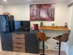 a desk with a television and two chairs in a room at Apartment Bergoase Spitzingsee in Schliersee