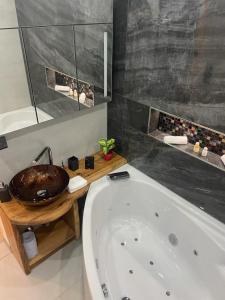 ein Badezimmer mit einer Badewanne und einem Waschbecken in der Unterkunft Apartment Bergoase Spitzingsee in Schliersee