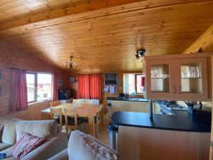 a kitchen and living room in a log cabin at Surf Lodge in West Down