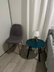 a chair and a table with a lamp next to a bed at Romantic apartments in Šibenik
