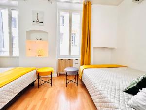 two beds in a room with white walls and orange curtains at 1 Bedroom flat with Balcony Cannes Center Croisette 6ppl in Cannes