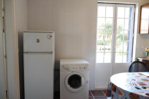 a kitchen with a refrigerator and a washing machine at Casa Azul in São Martinho do Porto