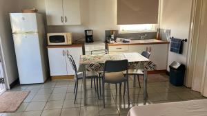 a kitchen with a table and chairs and a refrigerator at DAMYR PLACE in Faaa