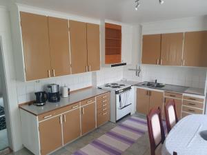 a kitchen with brown cabinets and a white stove top oven at Mysig lägenhet för resande in Stocka