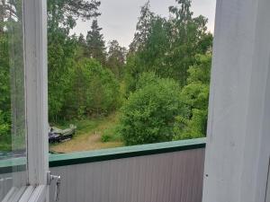 an open window with a view of a forest at Mysig lägenhet för resande in Stocka