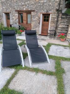 due sedie sedute di fronte a un edificio di Mini House - Roisan cir 0009 a Roisan
