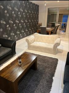 a living room with a couch and a coffee table at Beautiful 6 Bedroom with spacious Lounge & Rooms Free parking in Erith