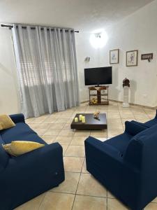sala de estar con sofá azul y TV en Panorama, en Lido Signorino