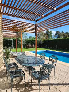 un patio avec une table et des chaises et une piscine dans l'établissement Casa en Club de Campo. Parque y Pileta., à San Nicolás de los Arroyos