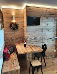 a room with a wooden wall with a table and a tv at Appartamento Campiglio 2 in Madonna di Campiglio