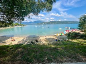 a beach with umbrellas and boats in the water at Gite Harmonie in Gréoux-les-Bains