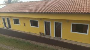 パライゾーポリスにあるPousada Dedo de Deusの黒いシャッターが付いた黄色い家