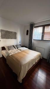 - une chambre avec un grand lit et 2 fenêtres dans l'établissement Apartament Willa Woda, à Jurata