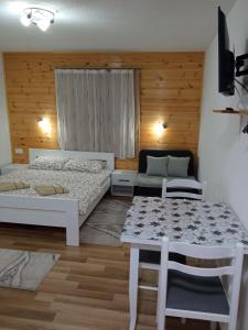 a small room with a bed and a table at Apartments Nemanja in Žabljak