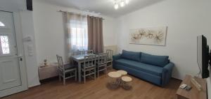 a living room with a blue couch and a table at Aeropis Villa, Chania in Chania