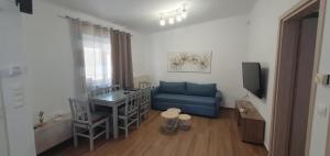 a living room with a blue couch and a television at Aeropis Villa, Chania in Chania