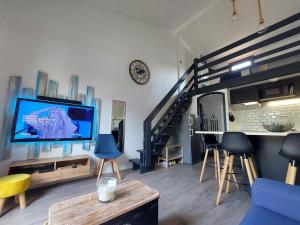 - un salon avec une télévision et un escalier dans l'établissement Maisonnette Les Sables, à Les Sables-dʼOlonne