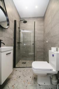 a bathroom with a white toilet and a shower at Akmenės svečių apartamentai Šypsena in Akmenė