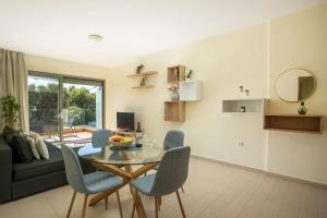 uma sala de estar com uma mesa de vidro e cadeiras em Eden Lily- Luxurious Apartment with Sea View em Rodes
