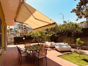 une terrasse avec une table, des chaises et un parasol dans l'établissement Siliade Apartment, à Montesilvano
