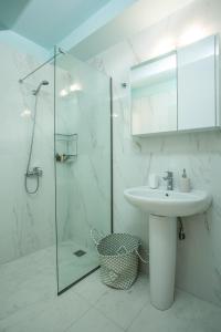 uma casa de banho com um lavatório e uma cabina de duche em vidro. em Eden Lily- Luxurious Apartment with Sea View em Rodes