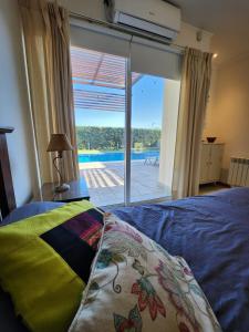 une chambre avec un lit et une vue sur une piscine dans l'établissement Casa en Club de Campo. Parque y Pileta., à San Nicolás de los Arroyos 43 autres photos