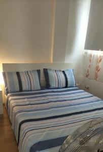 Bett mit blauen und weißen Kissen in einem Zimmer in der Unterkunft Domu Mia in Cattolica