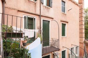 ein Apartmenthaus mit einer Wäscheleine und einem Balkon in der Unterkunft Ca' della scala in Venedig