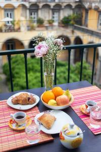 een tafel met borden en een vaas met bloemen bij CloisterVista apartment in Napels +13 foto's